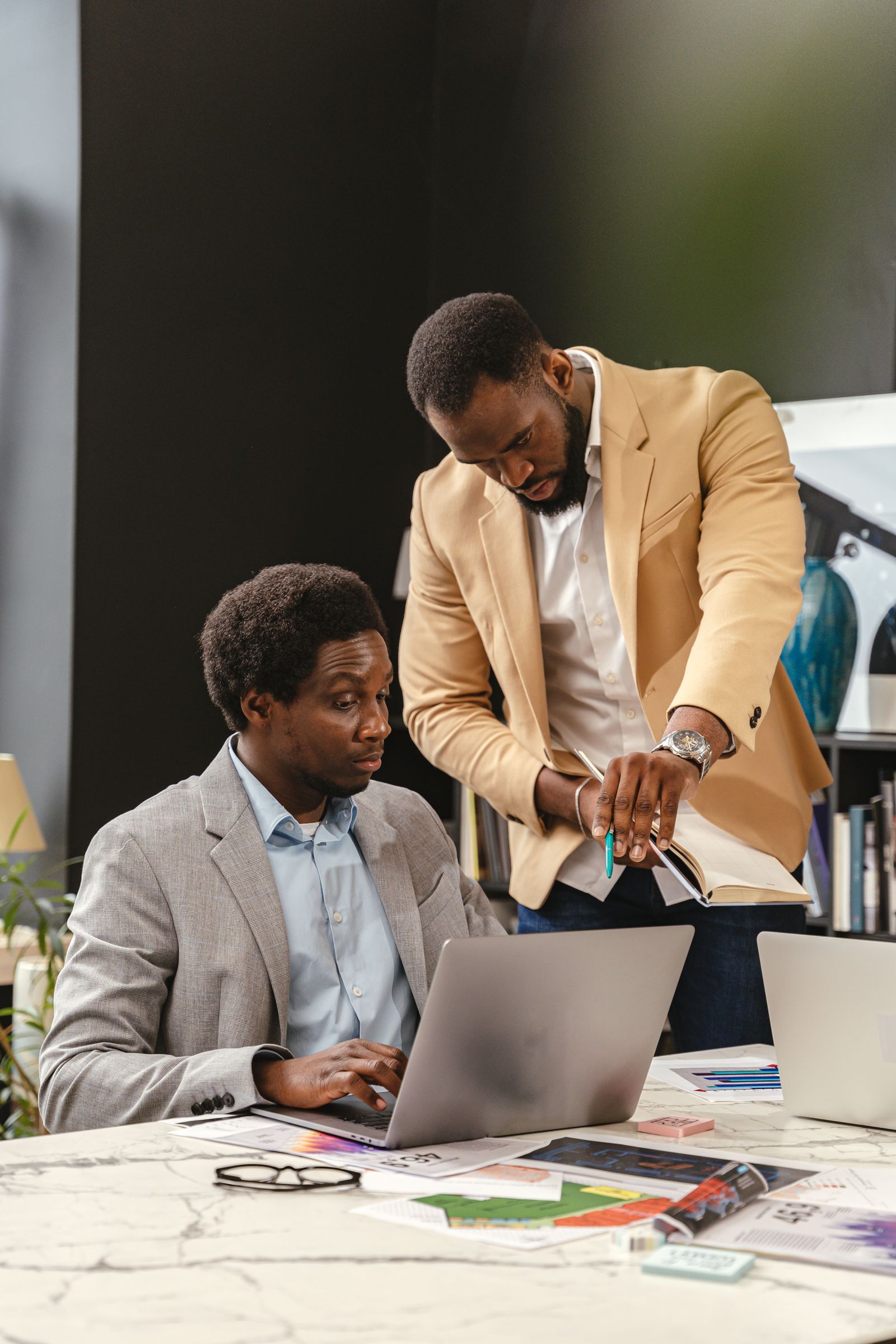 Two colleagues working together at a laptop in the office